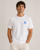 Model wearing a white Friends From New York T-shirt with a small blue dove logo on the left chest.